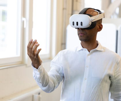 Person nutzt eine Virtual-Reality-Brille zur Interaktion mit einer digitalen Umgebung.